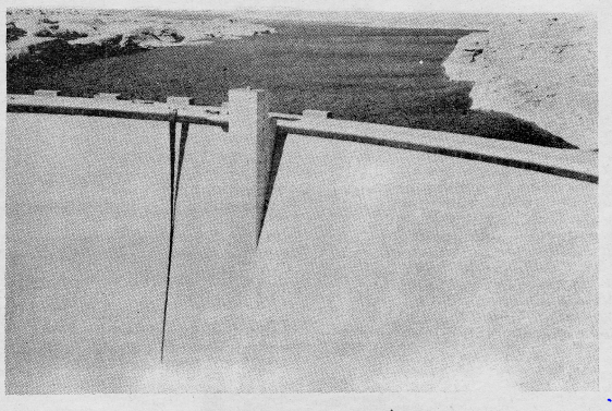 Grainy black and white photo of the Glen Canyon with a banner of a crack unfurled down the middle of it.