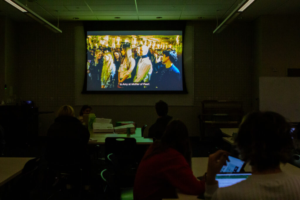 Students watch a documentary in a dark room.