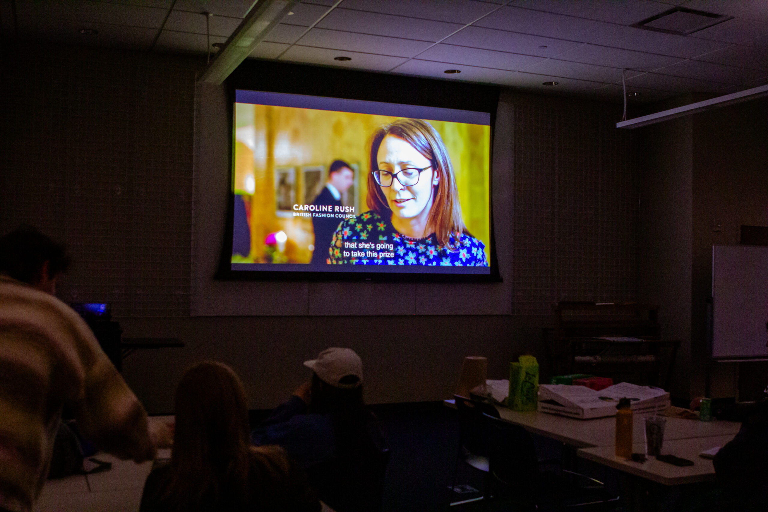Students watch a documentary in a dark room.