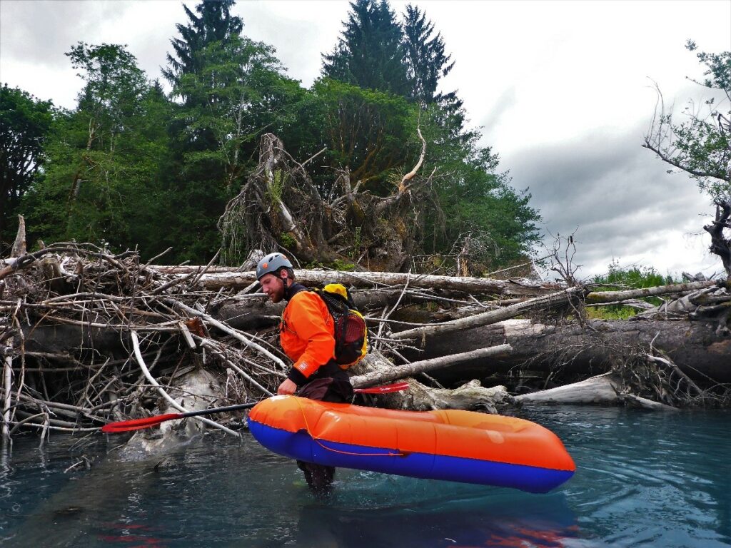 The author carrying his raft over a massive wood jam