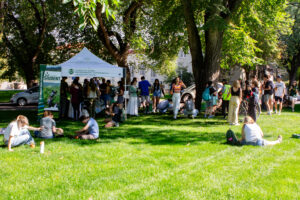 People gather underneath a tent outside.