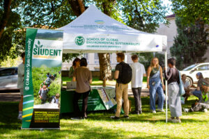 People gather underneath a tent outside.
