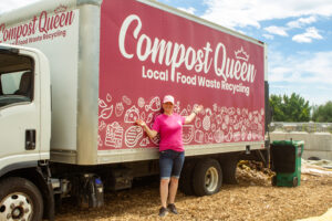 A woman wearing a pink shirt stands next to a pink delivery truck reading "Compost Queen."