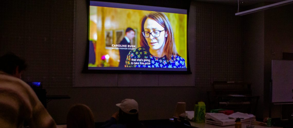 Students watch a documentary in a dark room.